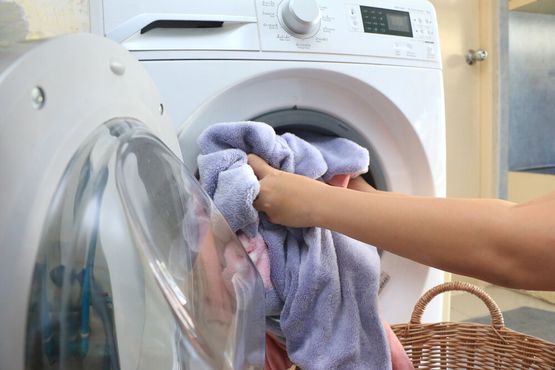 persona metiendo ropa en la lavadora